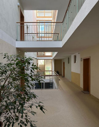 treppenhaus mit Sicht auf verschiedene Stockwerke und Wohnungstüren im betreuten Wohnen Wasserburg